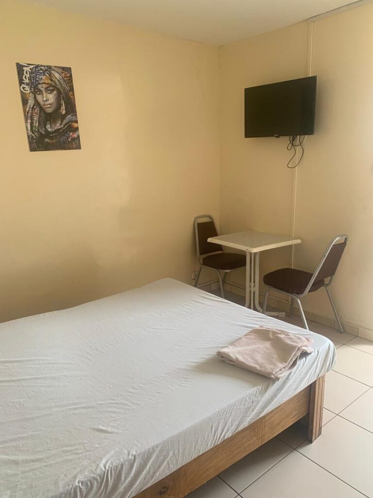 Chambre équipée d'une TV murale et d'un coin table